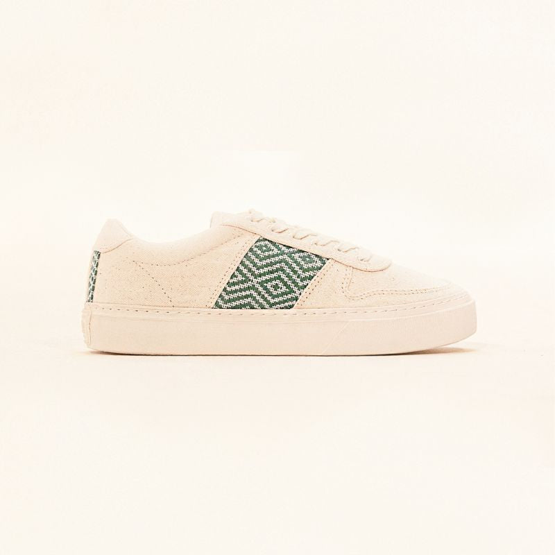 Nachhaltige Sneaker aus beigem Canvas mit handgewebtem Ethno-Muster in Smaragdgrün. Vegane Schuhe, fair und kunstvoll gefertigt in Vietnam – stilvoll, bequem und umweltfreundlich.