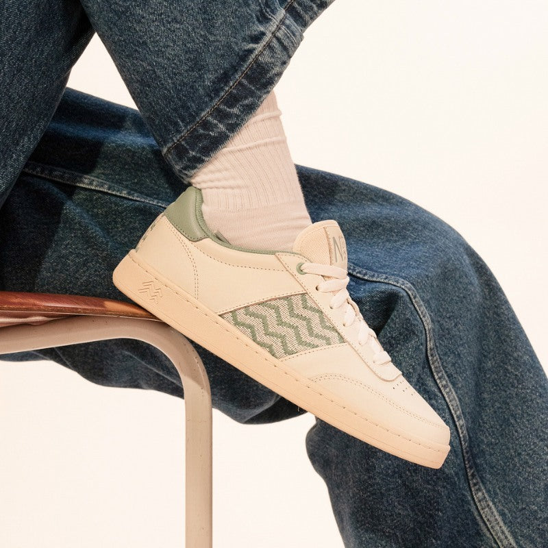 Nachhaltige Sneakers in Beige und Salbeigrün, getragen mit hochgekrempelten Jeans und weißen Socken.
Bequeme, handgefertigte Sneaker mit traditionellem Ethno-Muster und veganem Leder.