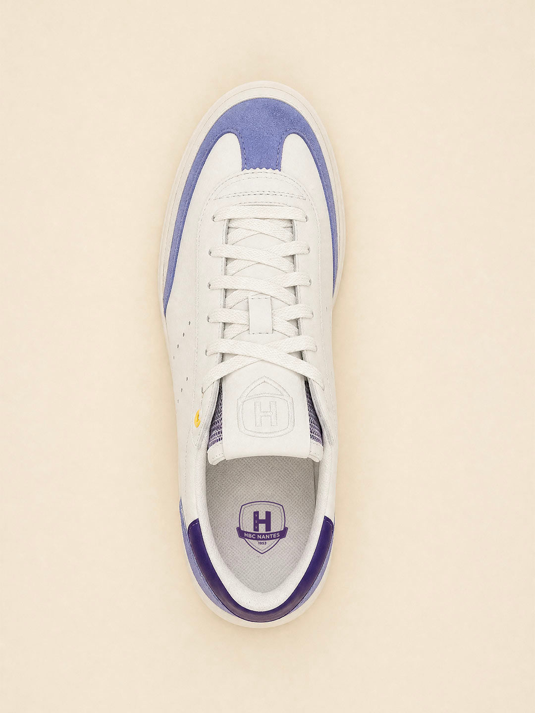Baskets blanches et violettes en vue de dessus avec logo HBC Nantes.