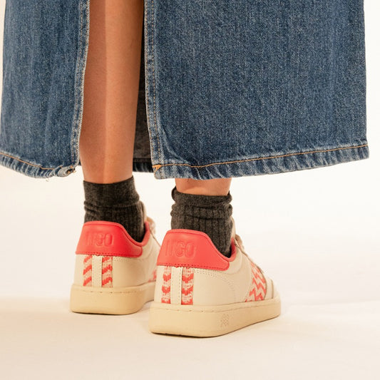 Nachhaltige Sneakers mit rotem Ethno-Muster, getragen mit Jeansrock und dunklen Socken.
Fair-Trade-Schuhe mit handgewebtem Design, inspiriert von vietnamesischem Kunsthandwerk.